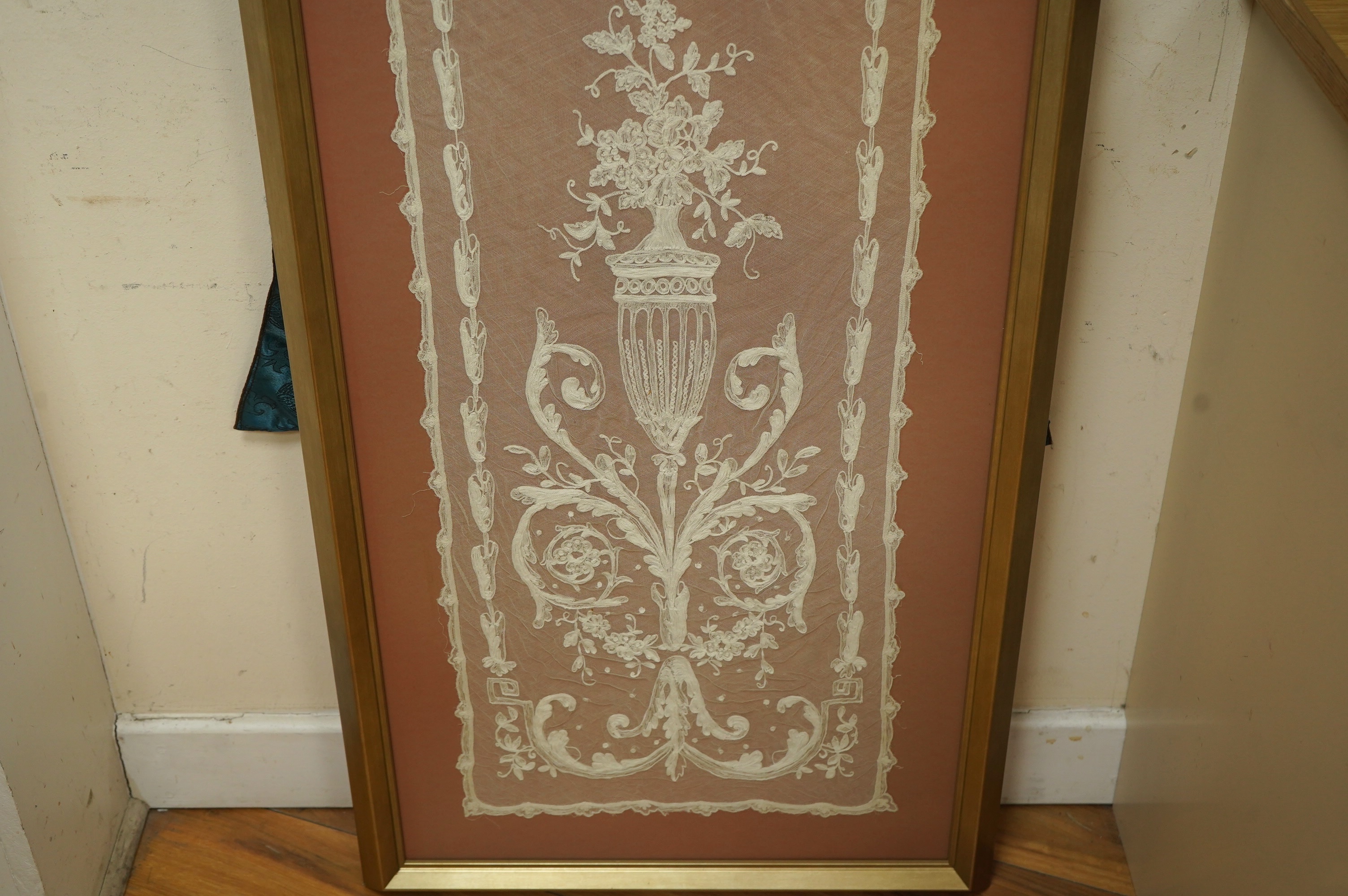 A framed Victorian white work needlerun lace stole with decorative urns and flowers each end, 154cm long x 33cm wide. Condition - has small darns to net one end, otherwise good.